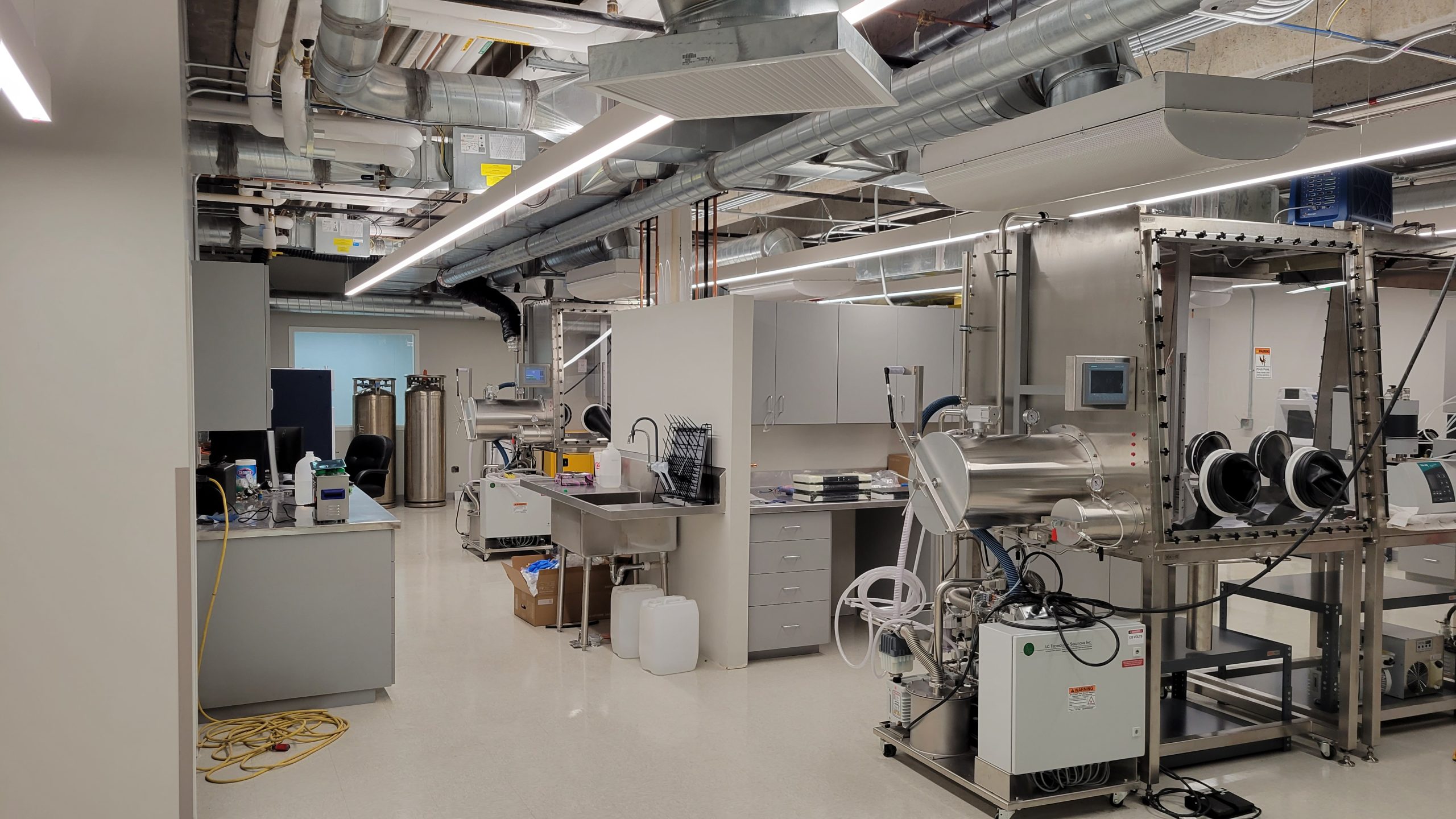 An image of the lab at Utah San Rafael Energy Labs showing part of an argon inert air glovebox, a handwashing station, inert gas tanks, and a desk and cabinet area